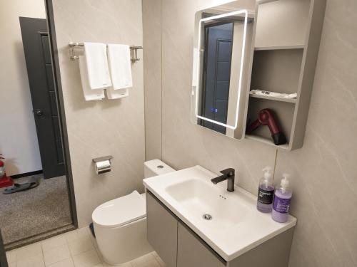 a bathroom with a sink and a toilet and a mirror at New Star Hotel in Chu-sung
