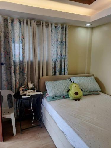 a bedroom with a bed with a pikachu toy on it at W Island Backpackers Inn in Dauis