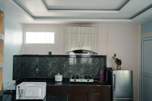 a kitchen with a black counter top and a refrigerator at Kathmandu Mountain view Studio in Bālāju