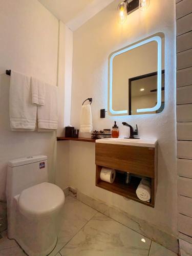 a bathroom with a toilet and a sink and a mirror at La Casona Suchitoto in Suchitoto