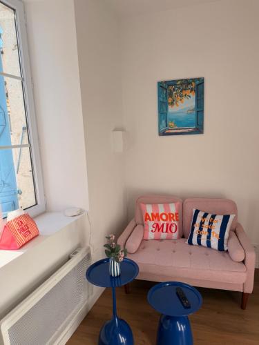 a living room with a pink couch and a window at Échappée Méditerranéenne in Lectoure