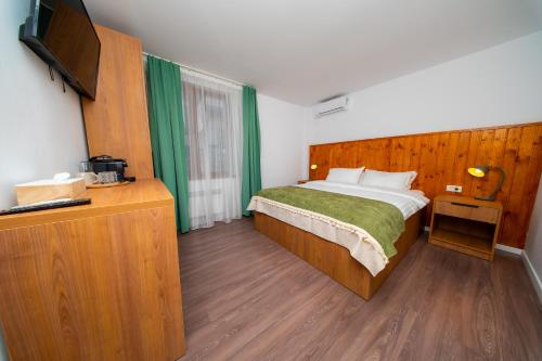 a bedroom with a bed and a flat screen tv at Pescariei Nr5 in Sarichioi