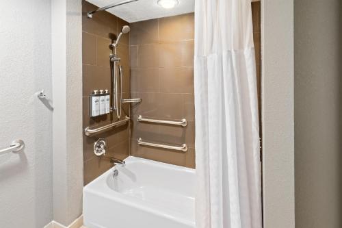a bathroom with a tub and a white shower curtain at Hyatt House Boston/Burlington in Burlington