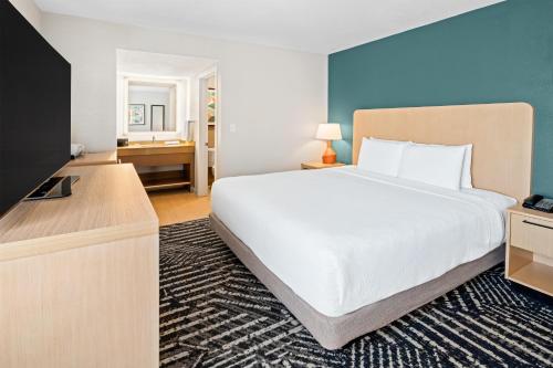 a bedroom with a large white bed and a television at Hyatt House Boston/Burlington in Burlington