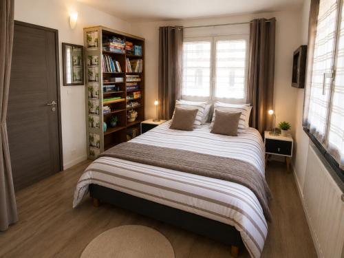 a bedroom with a large bed and a book shelf at LES FRUITS DE MER, plage et centre à pied, lits faits, parking gratuit, animal bienvenu in Berck-sur-Mer