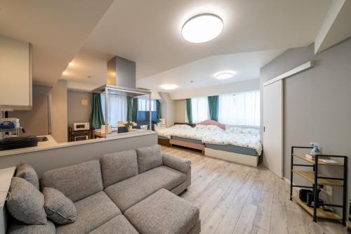 a living room with a couch and a bed at 高田馬場 Yoko hotel shinnjuku, shinokubo 10 people stay, big room in Tokyo
