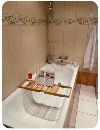 a bathroom with a bath tub with a book on it at Skøn perle midt i naturen in Munke Bjergby