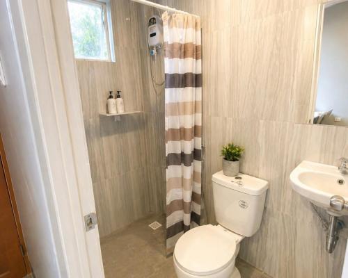 a bathroom with a toilet and a sink at Casa Amul in Tigbawan