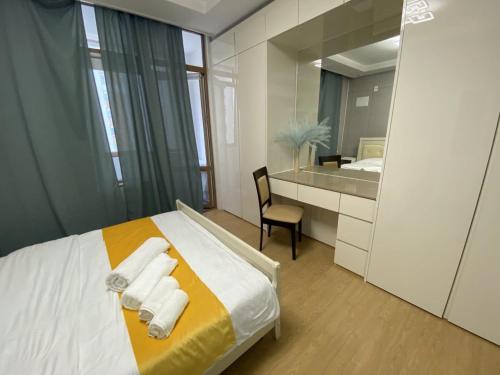 a bedroom with a bed and a desk and a mirror at Wh in HighVill in Astana