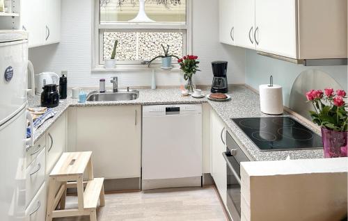 a white kitchen with white cabinets and a sink at Nice Home In Grenaa With Sauna in Grenå