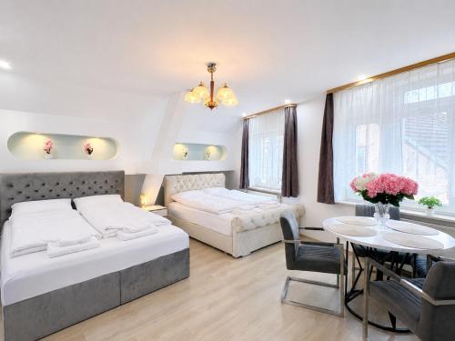 a bedroom with two beds and a table and a dining room at Hostel am Rhein - Nierstein in Nierstein