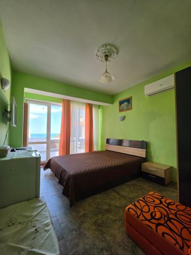 a bedroom with a bed and a large window at Студия Синя приказка in Sozopol