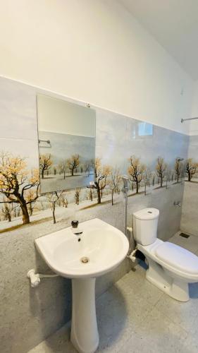 a bathroom with a white sink and a toilet at MAYU Homestay in Dickwella