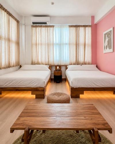 two beds in a room with pink walls at 大樹林 Mori Mori 包棟民宿 寵物友善 附車位 in Tainan