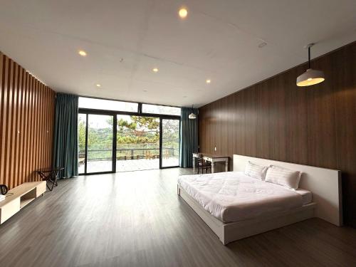 a bedroom with a white bed and a wooden wall at Michelia Valley Hotel in Da Lat