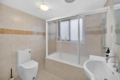 a bathroom with a toilet and a shower and a sink at Sapphire By The Sea in Diamond Beach
