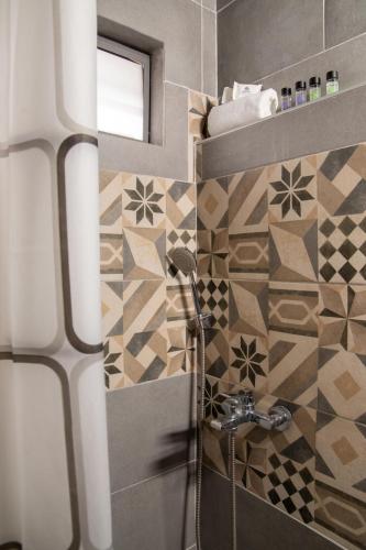 ein Badezimmer mit Dusche und geometrischen Fliesen in der Unterkunft Faros - Drosostalides, Milina in Milína