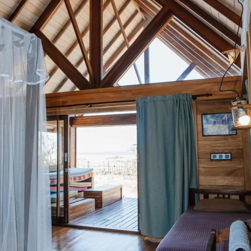 a room with a bed and a room with a window at Kitesurfing Lanka in Kalpitiya