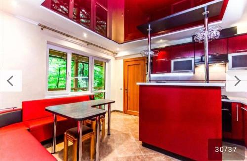a kitchen with red cabinets and a table and chairs at Над Річкою in Yaremche