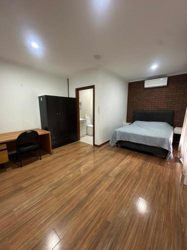 a bedroom with a bed and a desk and a room with a desk at Guest Room in Kealba in St Albans