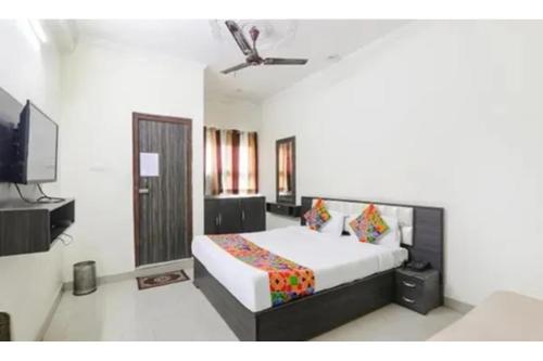 a bedroom with a bed and a flat screen tv at FabHotel Sara Residency in Prayagraj