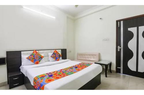 a bedroom with a large bed with a colorful blanket at FabHotel Sara Residency in Prayagraj