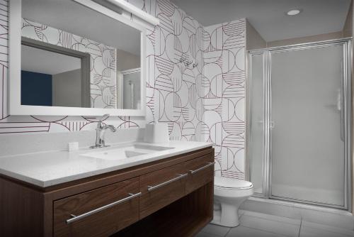 a bathroom with a sink and a toilet and a mirror at Home2 Suites by Hilton Florida City in Florida City