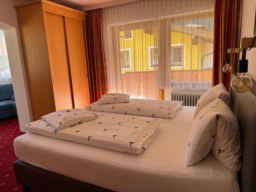 two beds in a room with a window at Pension Embacher GmbH & Co KG in Viehhofen