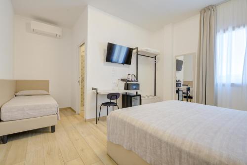 a hotel room with a bed and a desk and a television at Guest House al porto in Civitavecchia