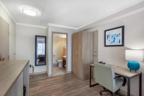 a room with a desk and a chair and a room with a bathroom at Quality Inn & Suites in Niagara Falls