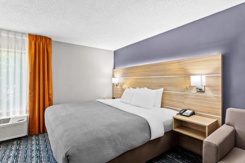 a hotel room with a bed and a chair at Quality Inn Rochester South in Rochester