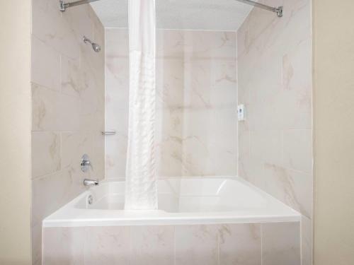 a white bath tub in a bathroom with marble walls at Comfort Inn Detroit Downtown in Detroit