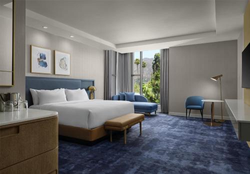 a hotel room with a bed and a desk and chair at Hilton Arcadia Los Angeles in Arcadia