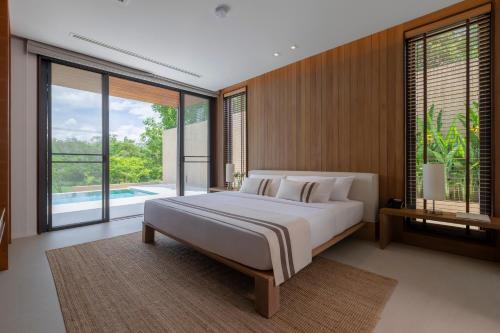 a bedroom with a large bed and a swimming pool at MUTHI MAYA Forest Pool Villa Resort - SHA Plus Certified in Mu Si