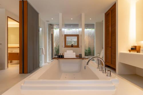 a bathroom with a large white bath tub at MUTHI MAYA Forest Pool Villa Resort - SHA Plus Certified in Mu Si