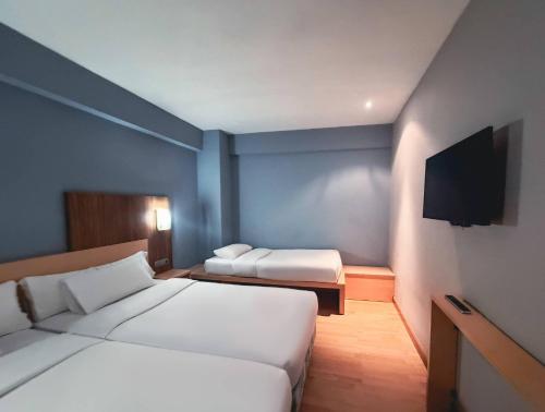 a hotel room with two beds and a flat screen tv at Hotel Faranda Alisas Santander, Ascend Hotel Collection in Santander