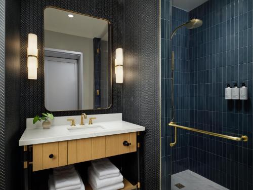 a bathroom with a sink and a mirror and a shower at Canopy By Hilton Deer Valley in Park City