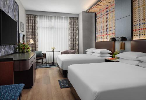 a hotel room with two beds and a desk at Canopy By Hilton Deer Valley in Park City