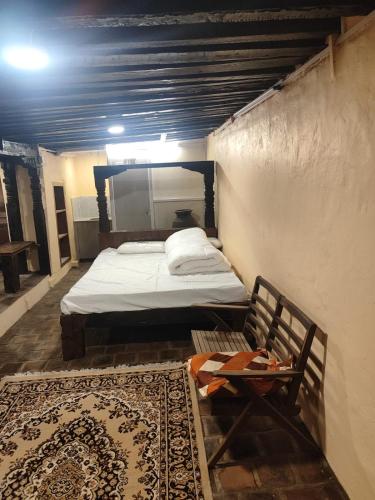 a bedroom with a bed and a chair and a rug at Sanjhyā Durbar Homestay in Bhaktapur