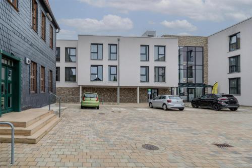 a parking lot with cars parked in front of buildings at ipartment Wolfsburg HOME by Best Western in Wolfsburg
