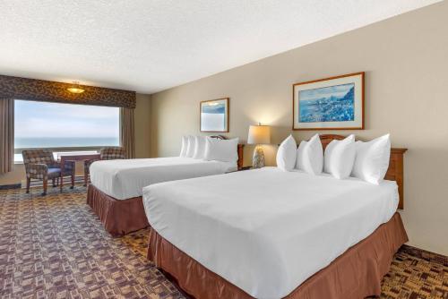 a hotel room with two beds and a table at Newport Oceanfront Inn in Newport