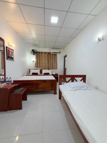 a bedroom with two beds and a table in it at Hotel Camorich in Tissamaharama