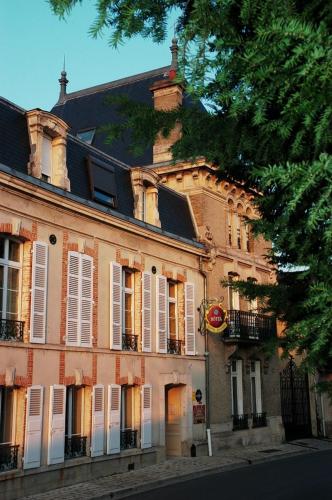 a large brick building with white doors and windows at Hôtel Castel Jeanson in Ay