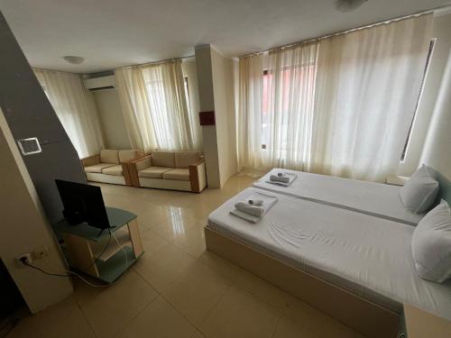 a bedroom with a bed and a chair and a laptop at Angel in Primorsko