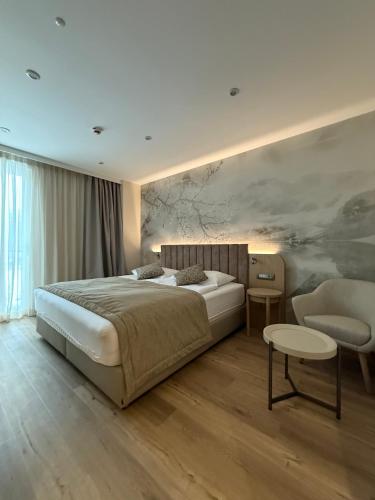 a bedroom with a bed and a couch and a chair at Hotel Korosica in Šentjanž pri Dravogradu