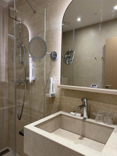 a bathroom with a shower and a sink and a mirror at Hotel Korosica in Šentjanž pri Dravogradu