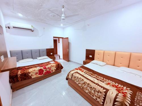 two beds in a hotel room with at Nisha sadan in Vrindāvan