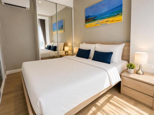 a bedroom with a large white bed and a mirror at Pool View 1 BR Apt for 3 - Diamond Condo 5209 in Bang Tao Beach