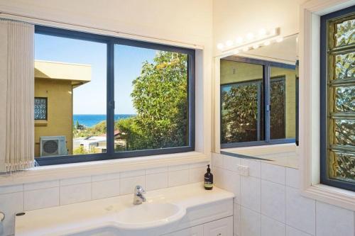 a bathroom with a sink and a large window at Kyeema in Tathra