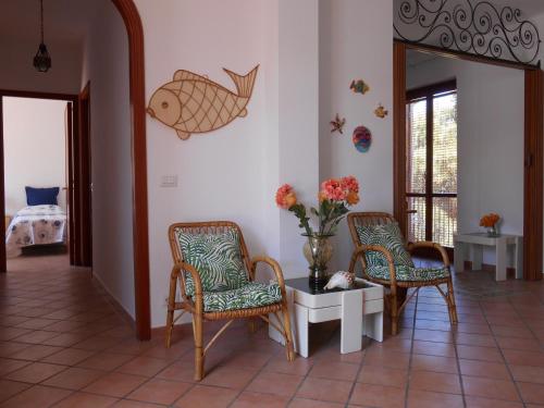 ジャルディーニ・ナクソスにあるCasa La Pergolaのリビングルーム(椅子、テーブル付)、壁に魚が備わります。